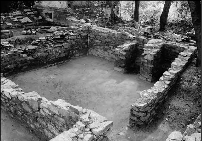 A black and white photograph showing the stone building foundation of the Mason House.