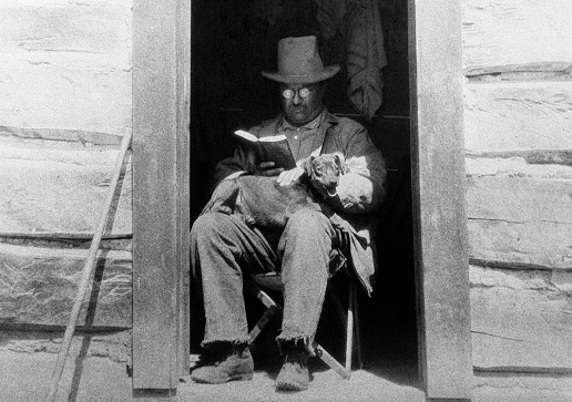 T.R. reading a book, with his dog, Skip.