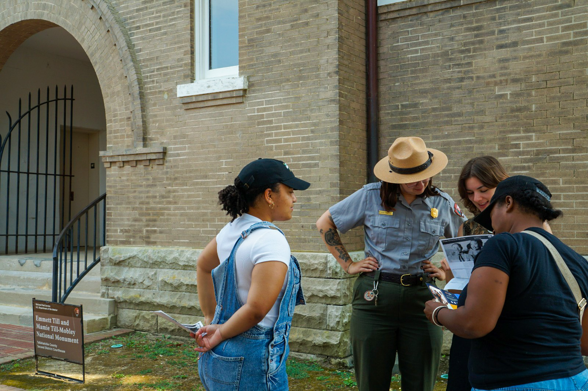 Several visitors and a ranger examine a park map