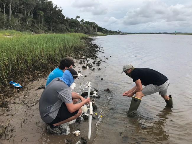 students install PVC pipe device at oyster bed