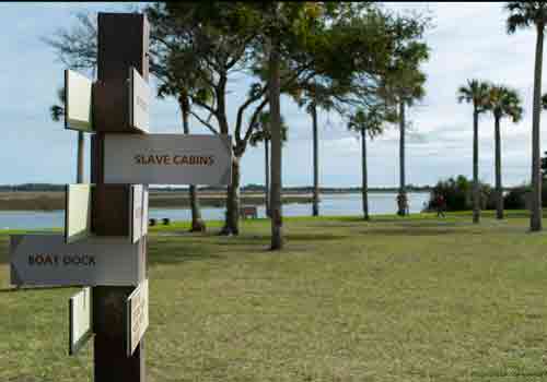 directional sign point out restrooms at the park with grass in the background