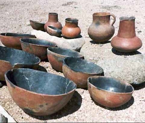 Image depicting red and black handmade pottery of various sizes.
