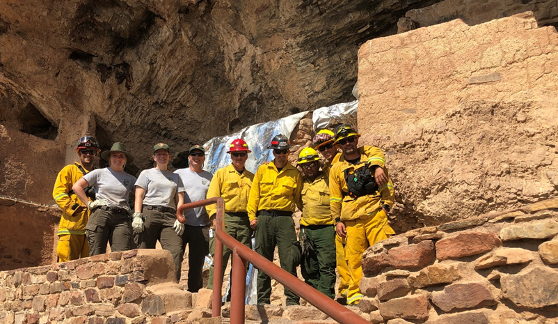 Crew in front of wrapped cliff dwelling