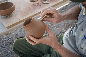 Park ranger demonstrating how to make pottery