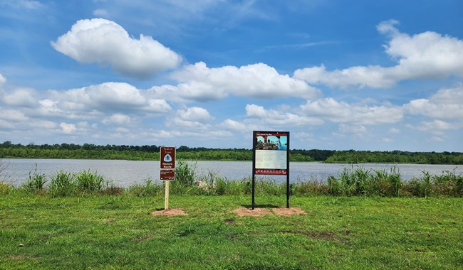 A wayside exhibit next to a lake.