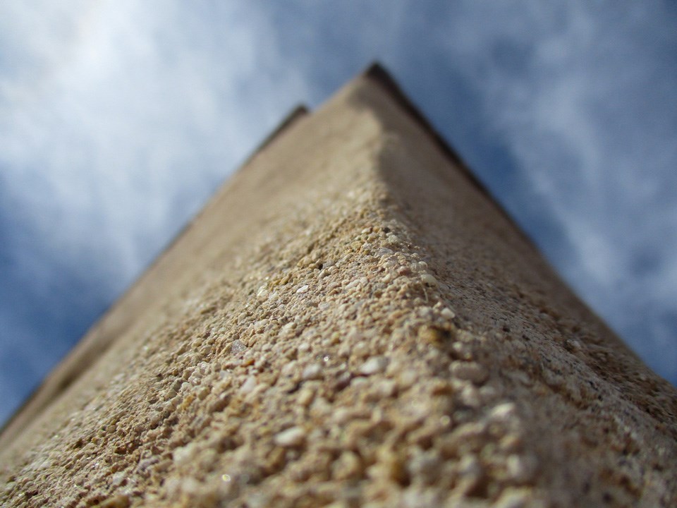closeup of corner adobe building looking toward sky