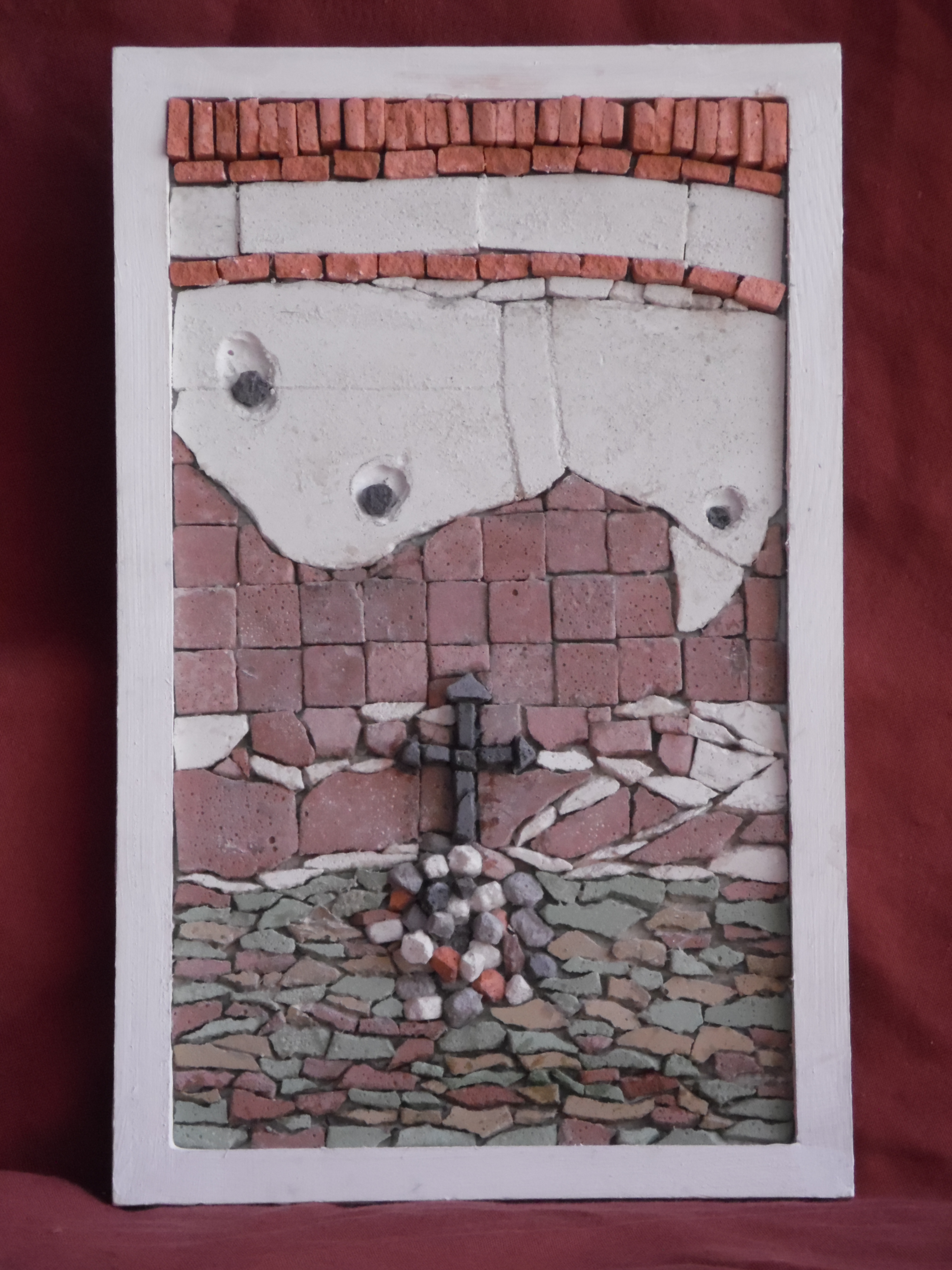 A framed mosaic of church altar and cross.