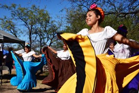 smiling young dancer with mexican yellow skirt