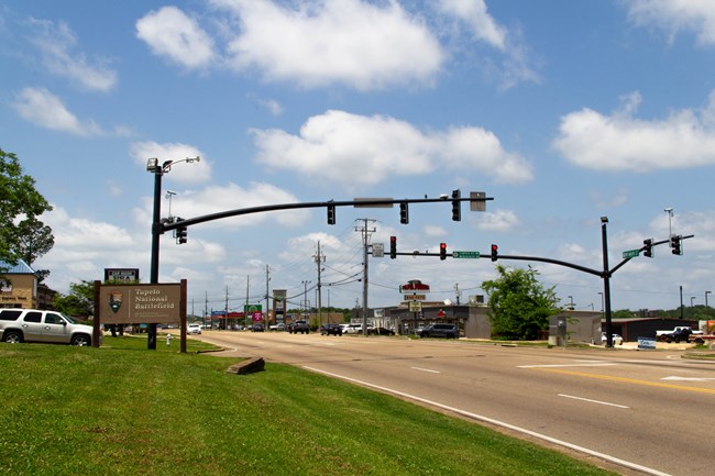 A photograph of the National Park sign for Tupelo National Battlefield next to a busy road.