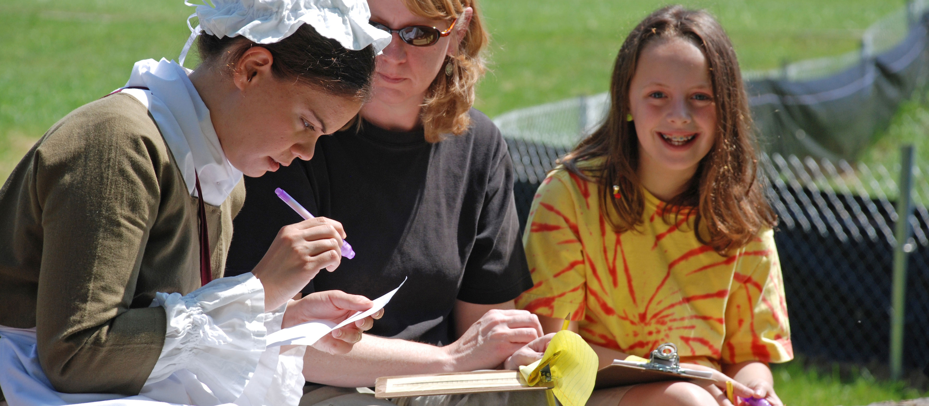 A young woman in colonial clothing helps visitors discover secret writings in invisible ink.