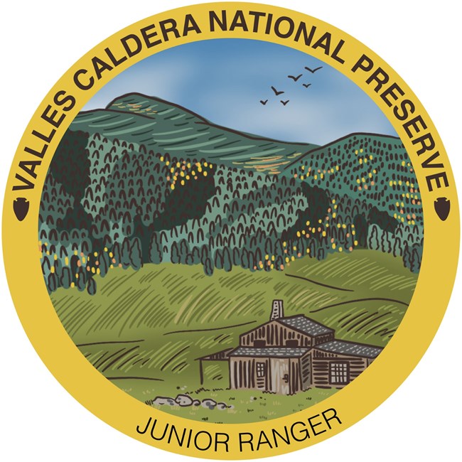 A circular patch that says Valles Caldera Virtual Junior Ranger. On the patch is a color illustration of an old cabin overlooking a grassland and distant mountains.