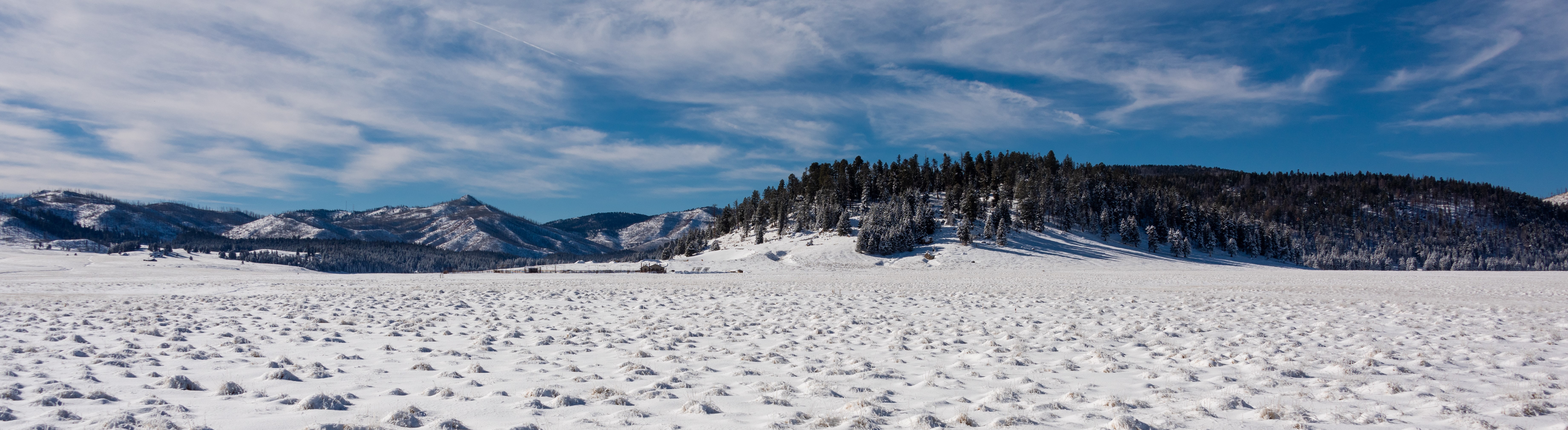 An expansive, snowy valley with distant mountains.