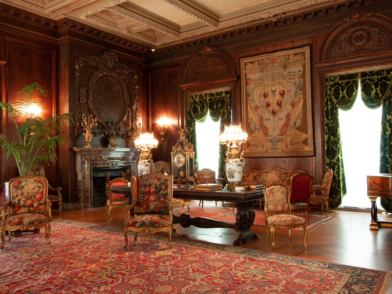 A richly decorated room with tapestries and gilt furniture.