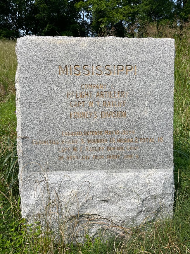 A piece of stone with a gold letter inscription on the front