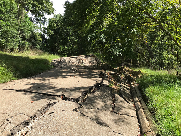 Road with damage including large crack and sections of the road dropped a few feet