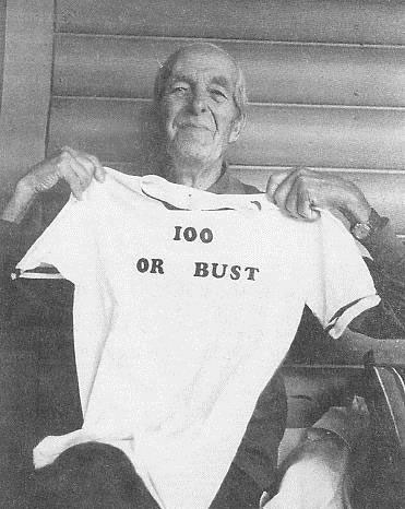 I.W. Stevens holding up a tshirt that says 100 or bust, celebrating his 100th birthday