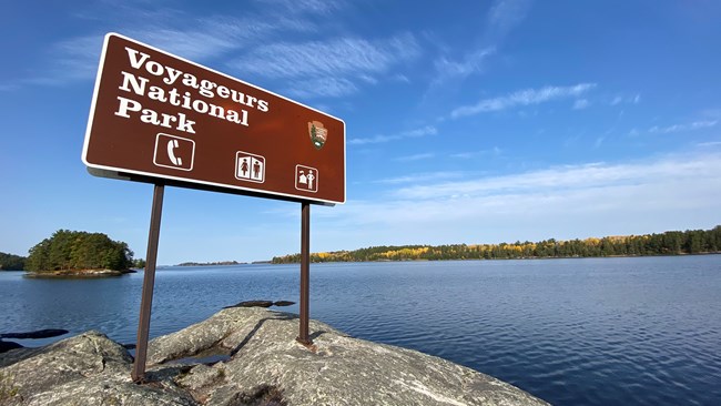 A Voyageurs National Park sign sits on a rock point on Kabetogama Lake