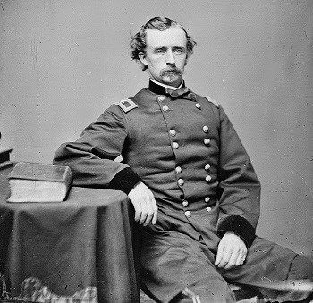 George Armstrong Custer, 1864 photograph showing him seated with right elbow resting on table.