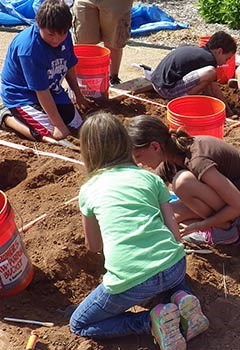 Students digging for replica fossils.