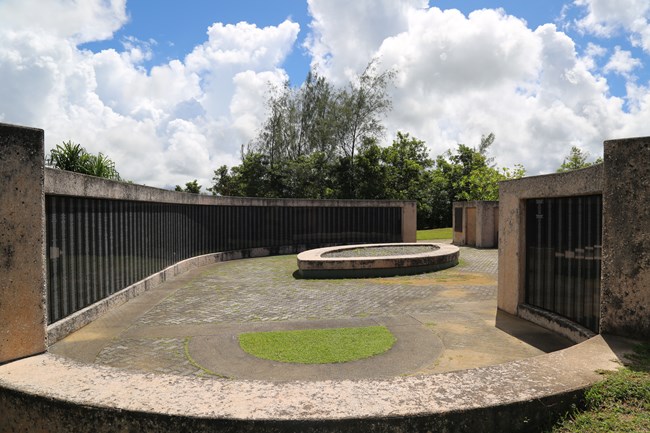 Curved concrete walls inset with plaques covered in names.