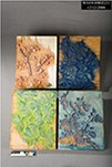 Image of 4 carved woodblocks used for making a print, each with a different design and color, including red, dark blue, light blue, green.