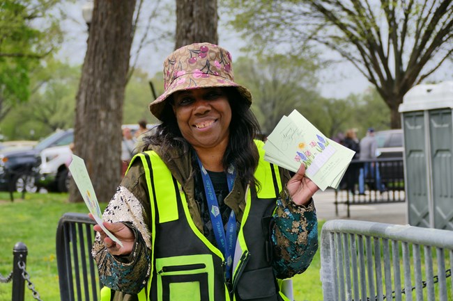 Volunteer holding Garden Tour tickets