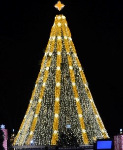 Christmas tree decorated with a cascade of white and golden colored lights with a four point star on top