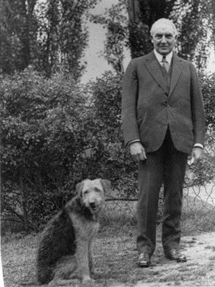Warren Harding in the White House gardens with a large shaggy dog.
