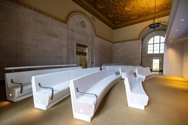 Four rows of bench seating with clear floor space in the front row for a wheelchair.