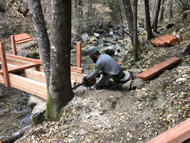 Park maintenance staff finishing up the construction of a new footbridge near Whiskeytown Falls. The former footbridge burned in the fire. NPS Photo.