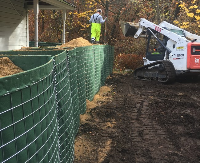 Park staff installing Hesco barriers.