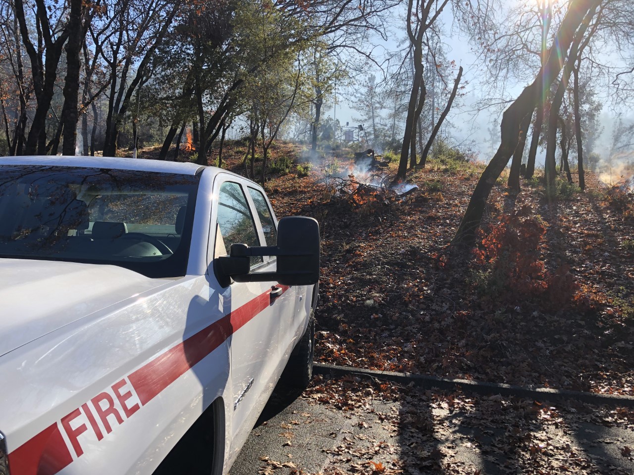 Whiskeytown fire vehicle monitoring a burn pile located on the hillside behind it.