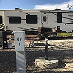An RV site with a grill and RV