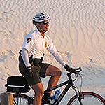 Law enforcement ranger rides bicycle in the dunes