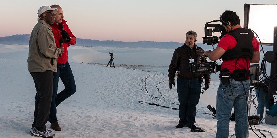 Two men being filmed on the dunes.