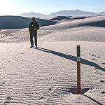 Man hiking on white sand dunes
