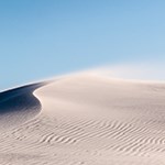 Sand being blown across dune
