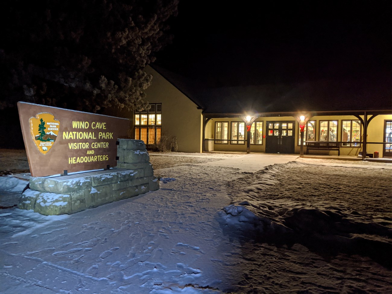 Nighttime outside the visitor center with snow covering the ground.