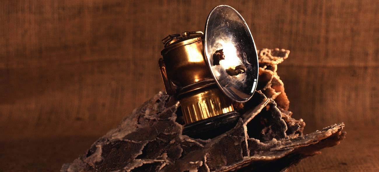 a carbide lamp sits on a piece of boxwork
