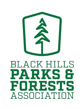 Black Hills Parks and Forests Association logo with a pine tree line drawing above green letters.