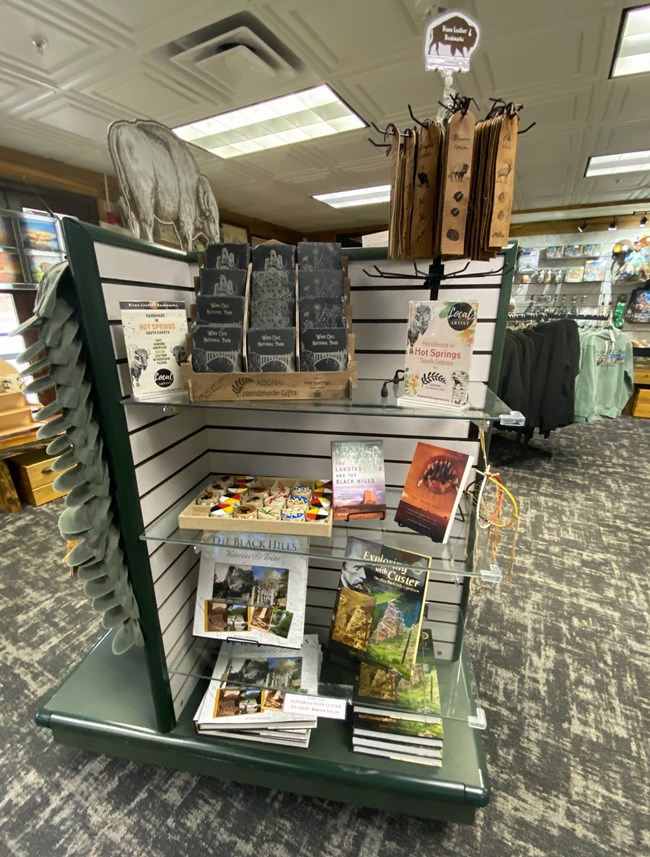 A display in the park store with books and souvenirs stacked on its shelves.