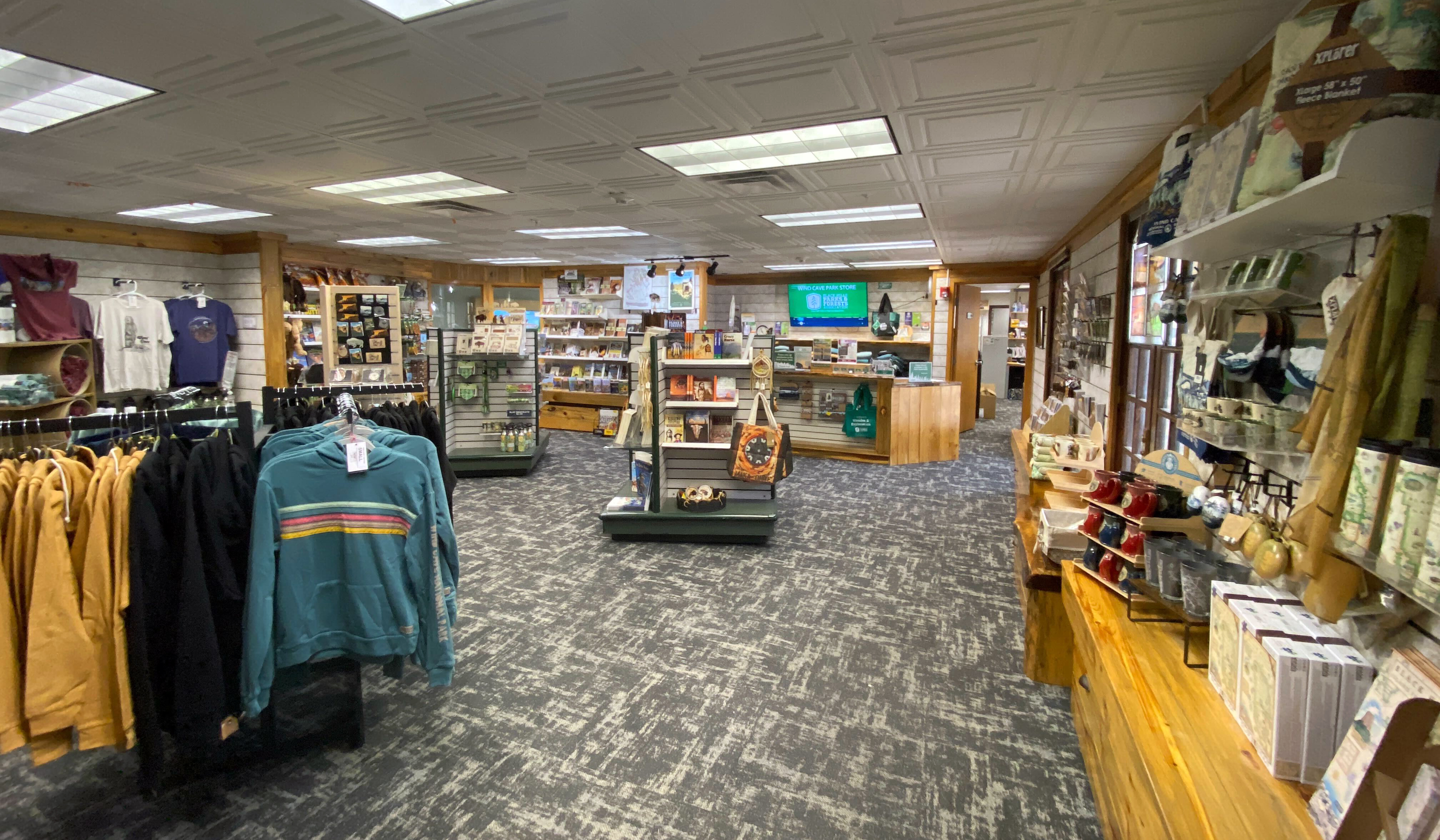View of the park store with racks of clothing and shelves of books and souvenirs.
