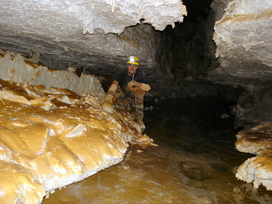 Cave explorer Carl Bern kneeling next to Lake Vega on a recent exploration trip in the southwest corner of the cave.