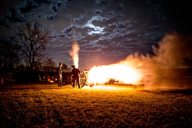 Night Cannon Firing with orange flames shooting out of vent and barrel after the command of fire!