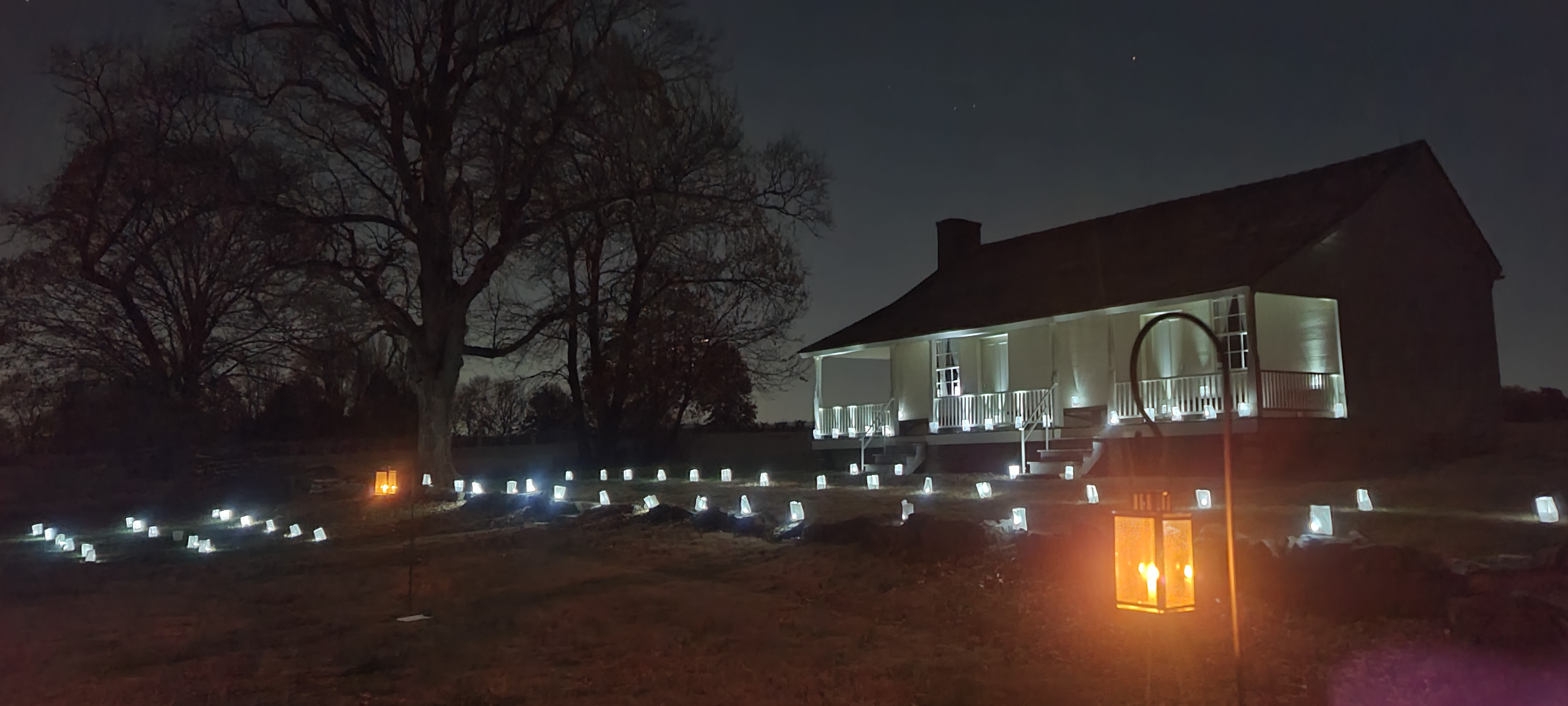 Paper lanterns illuminate the area near an historic house.