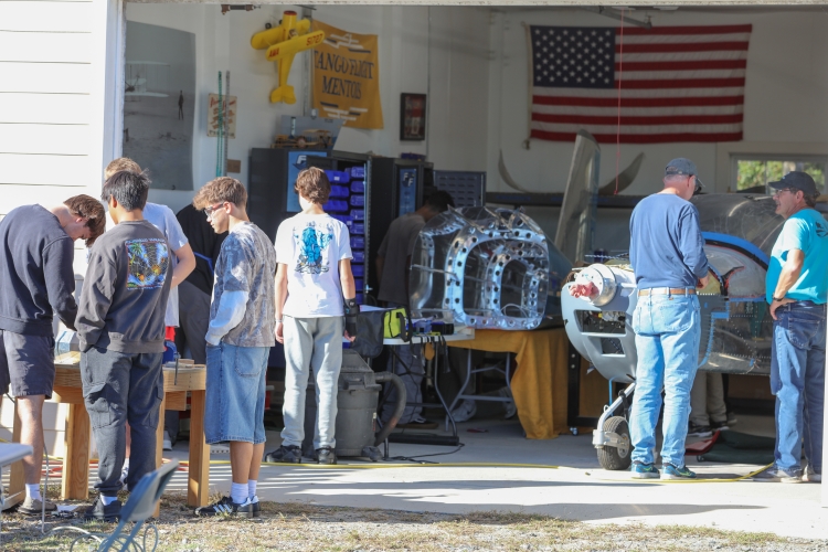 Image of students working inside and outside an aviation lab.