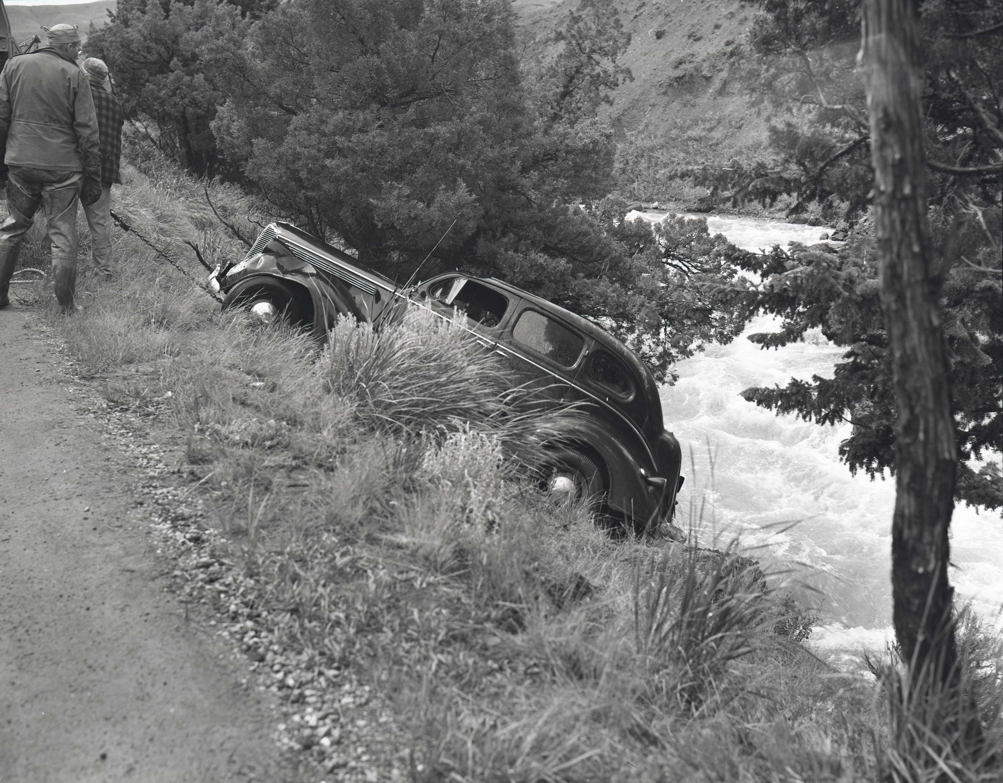 Image of a car being towed up a steep riverbank.