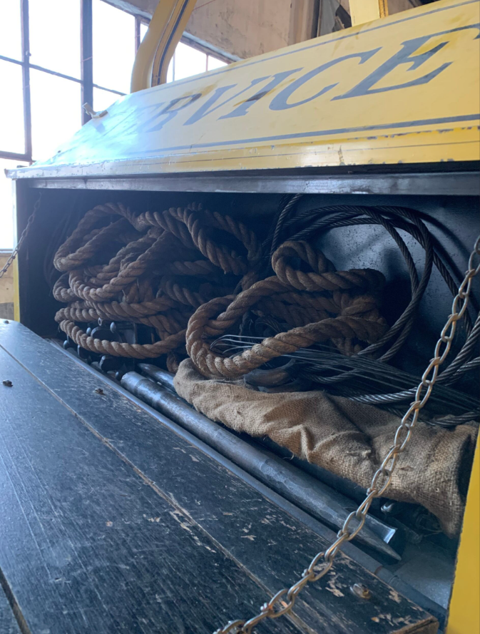 Image of hatch compartment of wrecker vehicle, containing rope and other supplies.