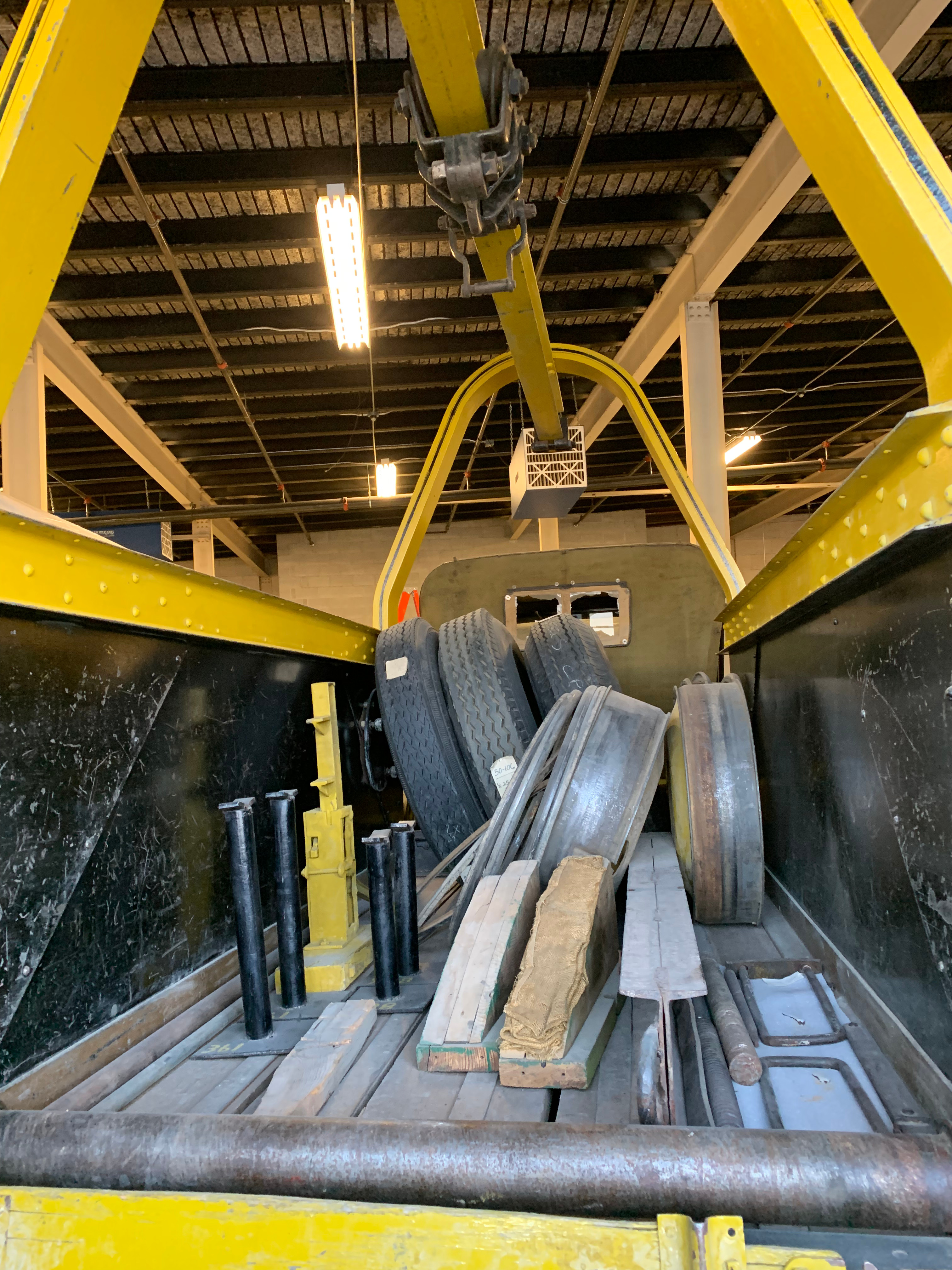 Image of storage compartment of a wrecker, containing tires and wood blocks.