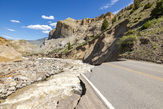 A road that previously ran through a canyon that was damaged by a flood